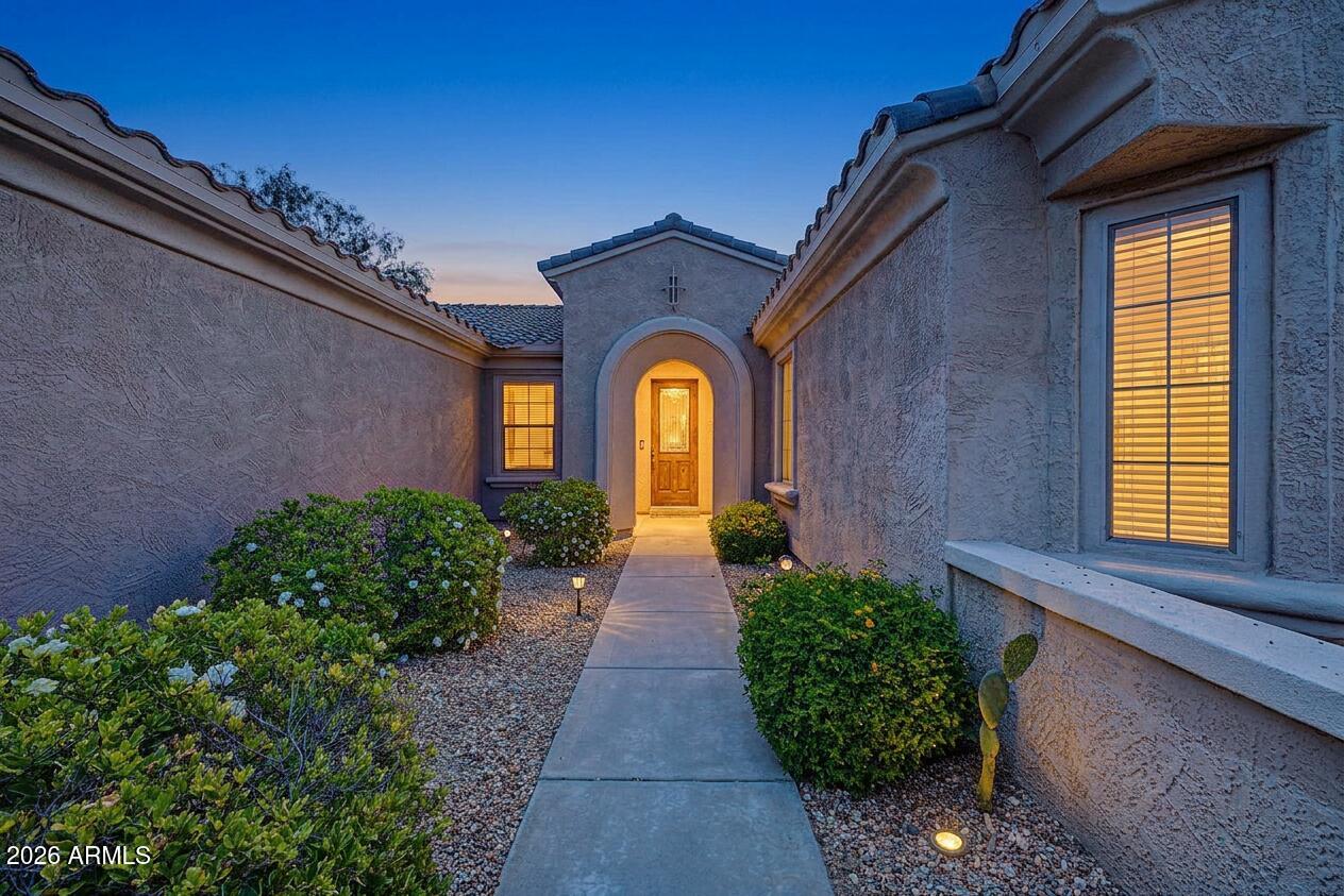 16731 West Oracle Rim Drive Surprise, AZ 85387 - Photo 4 of 54 a view of a brick house with potted plants