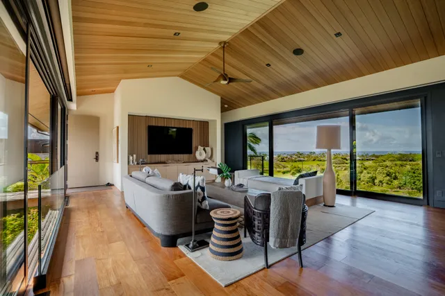 a living room with furniture floor to ceiling window and wooden floor