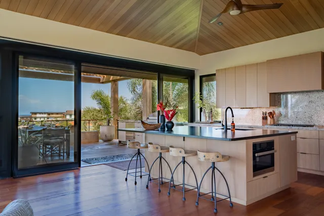 a kitchen with stainless steel appliances granite countertop a stove top oven a dining table and chairs with wooden floor