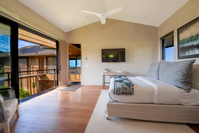 a spacious bedroom with a bed and a flat screen tv