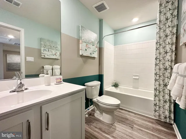 a bathroom with a sink toilet vanity and shower