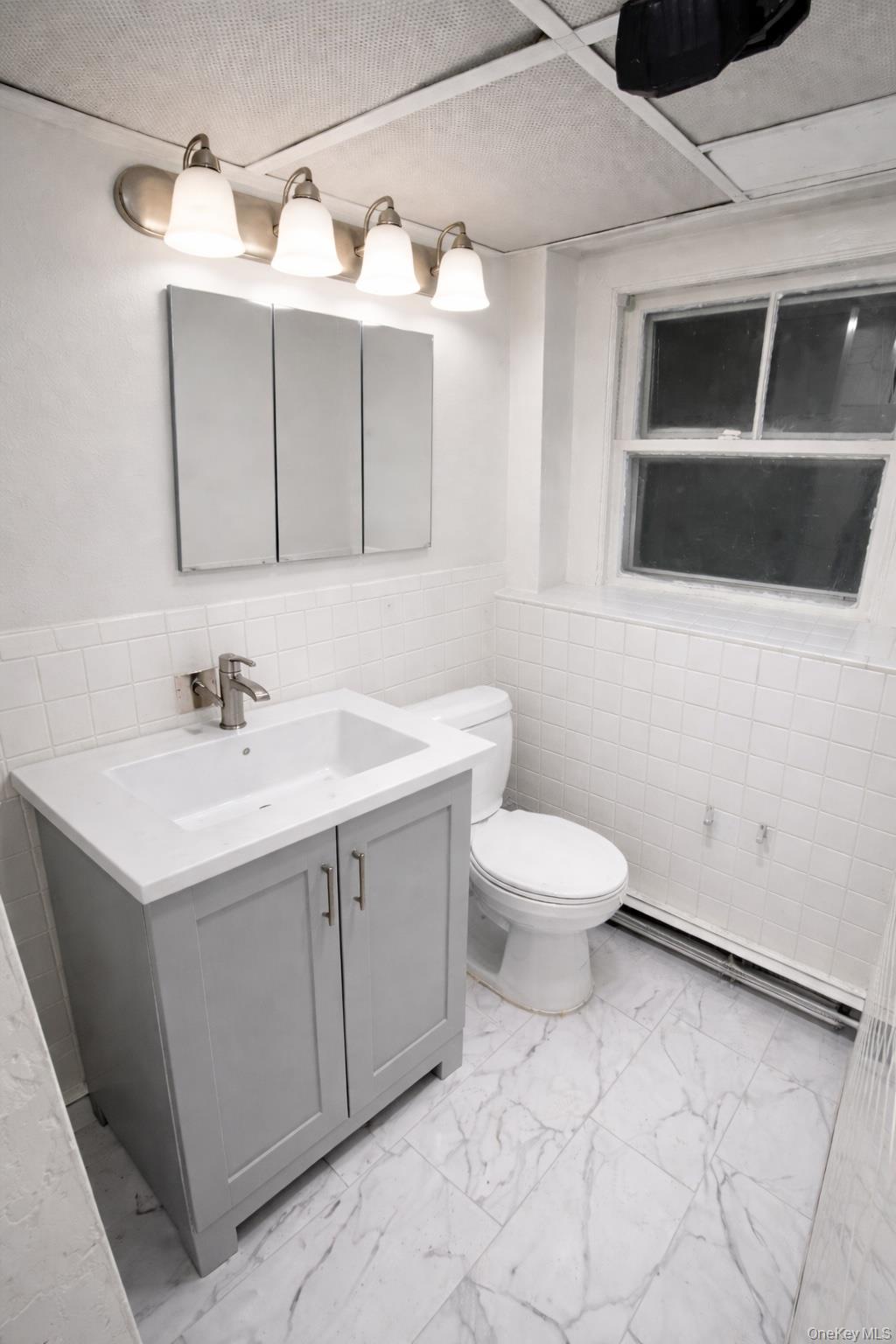 278 Mile Square Road Yonkers, NY 10701 - Photo 8 of 8 a bathroom with a sink a toilet and mirror