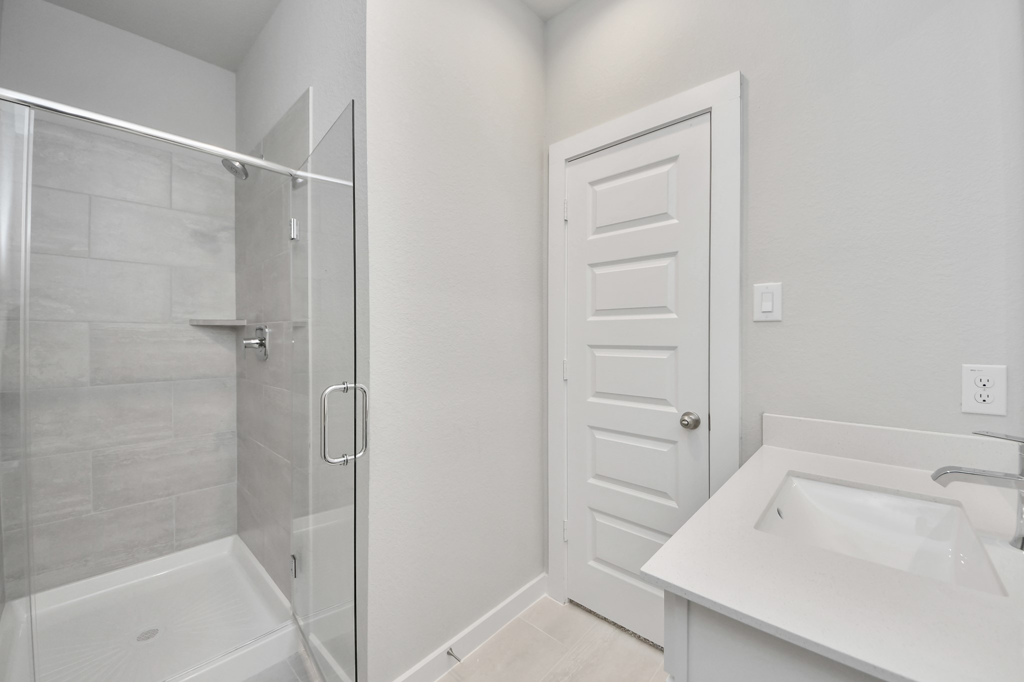 311 Ice Shr Trail Dayton, TX 77535 - Photo 6 of 35 Secondary bath features tile flooring, a walk-in shower with tile surround, light stained wood cabinets, beautiful light countertop. Sample photo of completed home with similar floor plan. Actual colors and selections may vary.