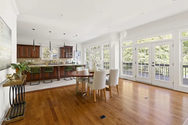 a living room with stainless steel appliances granite countertop furniture wooden floor and a large window