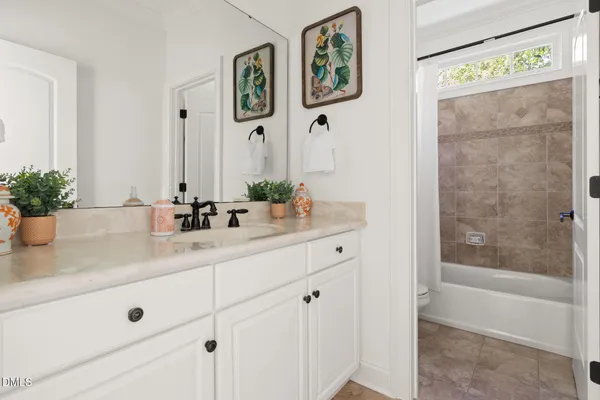 a bathroom with a granite countertop sink a mirror a vanity and shower