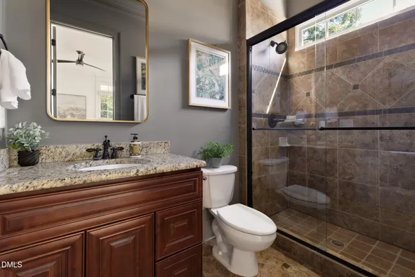 a bathroom with a granite countertop sink toilet and shower