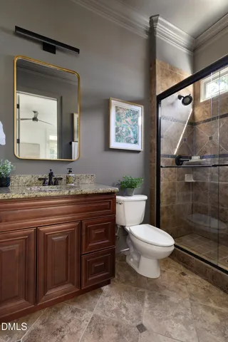 a bathroom with a granite countertop toilet a sink and a mirror
