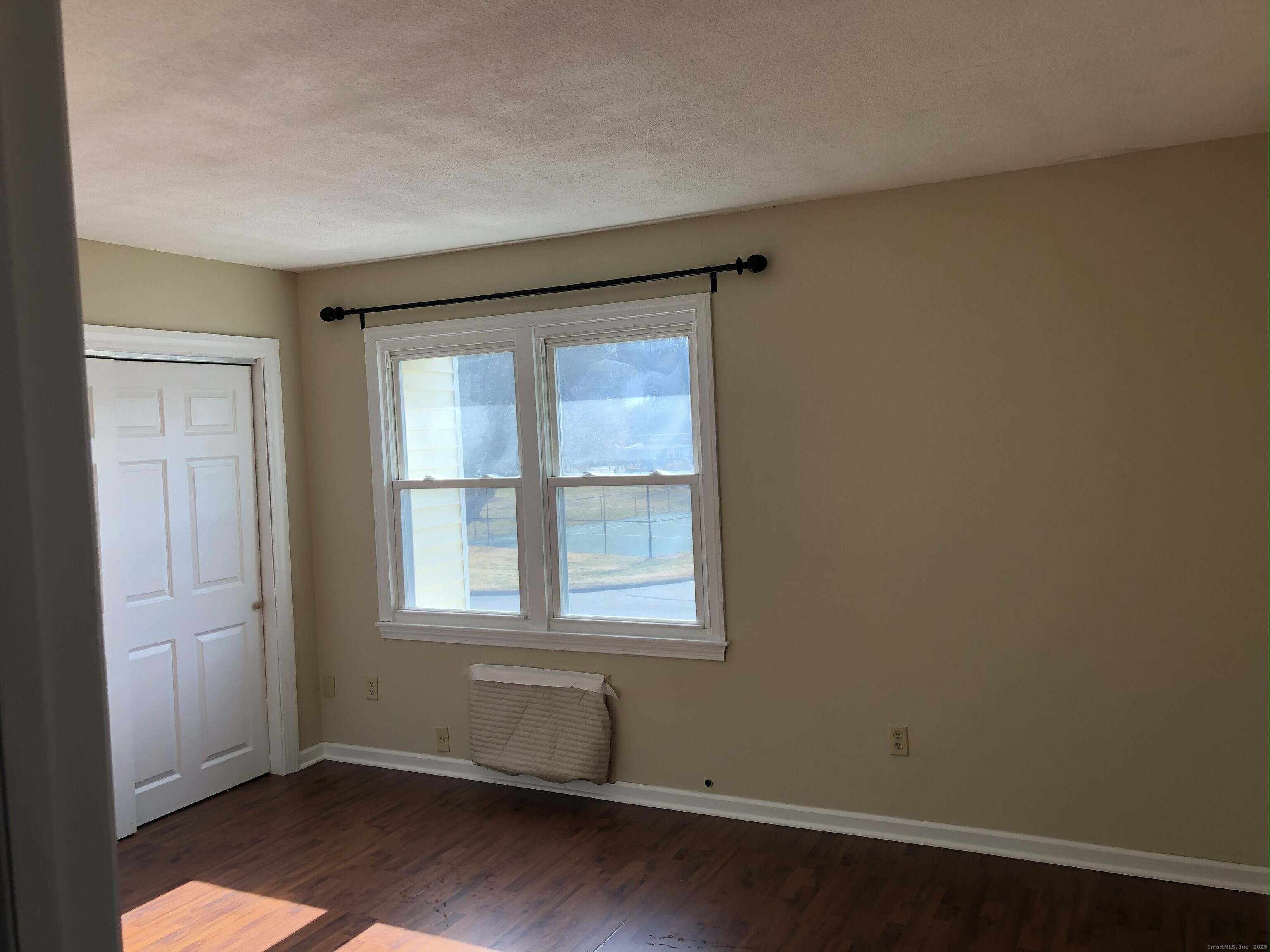 127 Black Point Road, Unit 7 East Lyme, CT 06357 - Photo 9 of 15 an empty room with wooden floor and windows