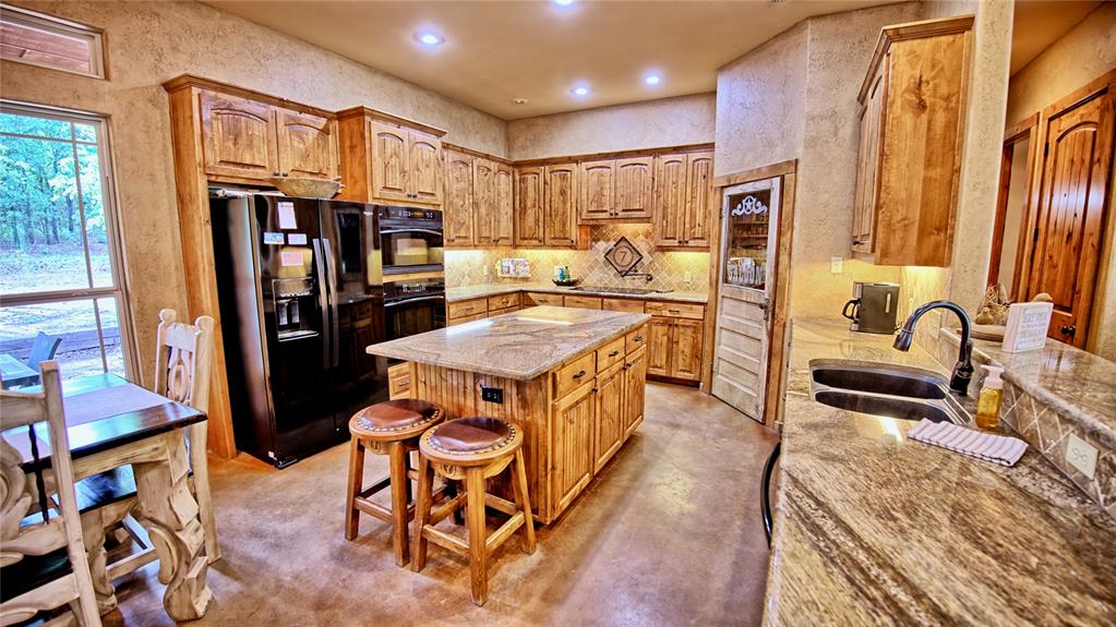 4509 Lazy E Road St. Jo, TX 76265 - Photo 6 of 39 a kitchen with stainless steel appliances granite countertop sink refrigerator and stove