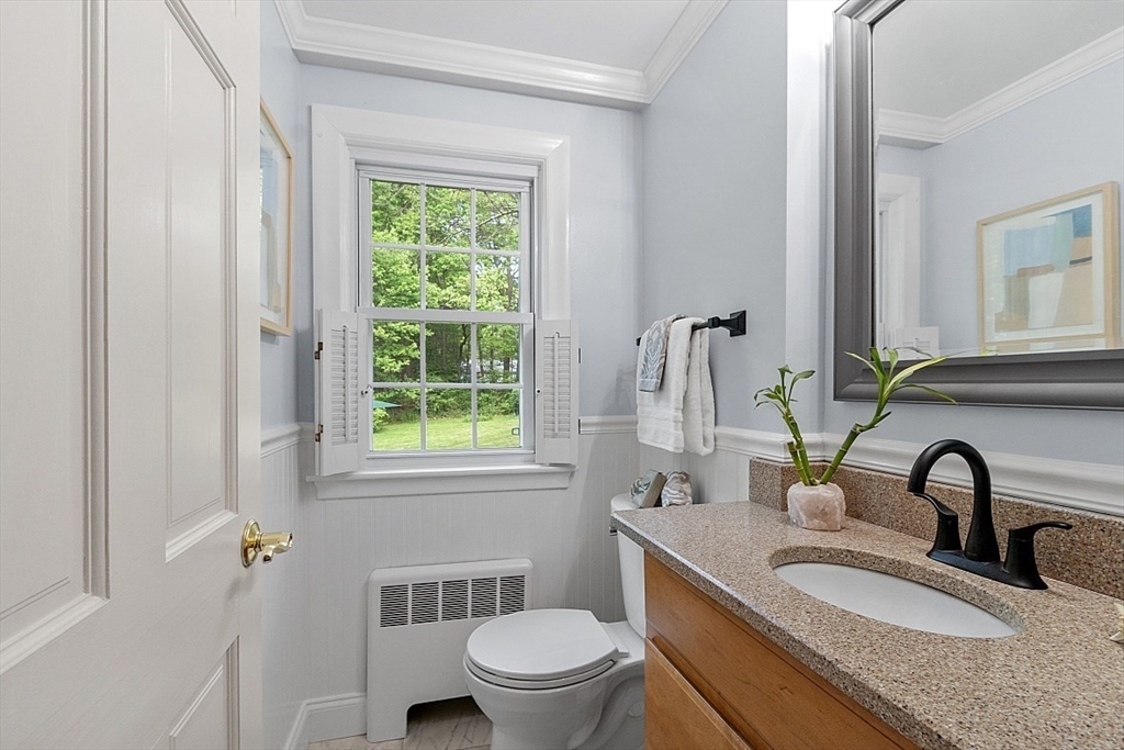 130 Adams Road Concord, MA 01742 - Photo 15 of 33 a bathroom with a granite countertop toilet a sink a mirror a window and vanity
