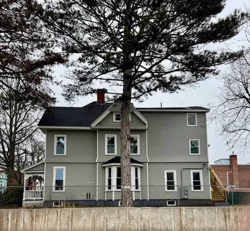 a front view of a house with a tree
