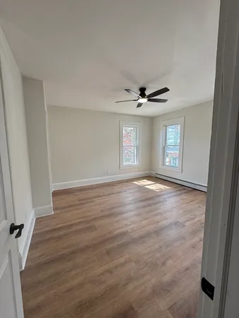 a view of a livingroom with wooden floor and window