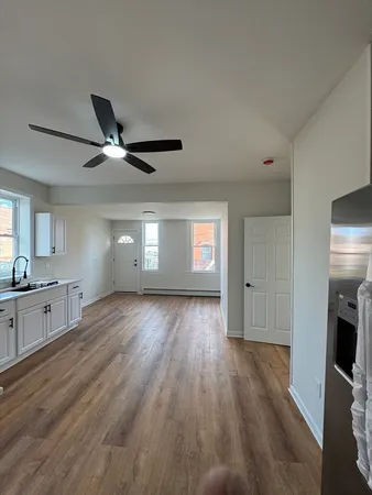 a large kitchen with cabinets wooden floor and stainless steel appliances