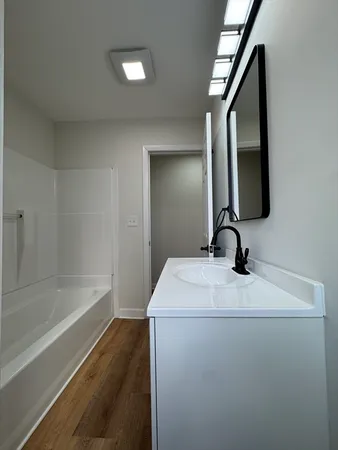 a view of empty room with wooden floor and fireplace