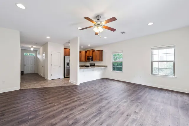 a view of a livingroom with wooden floor and a ceiling fan