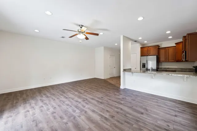 a kitchen with stainless steel appliances granite countertop a refrigerator a stove and a sink