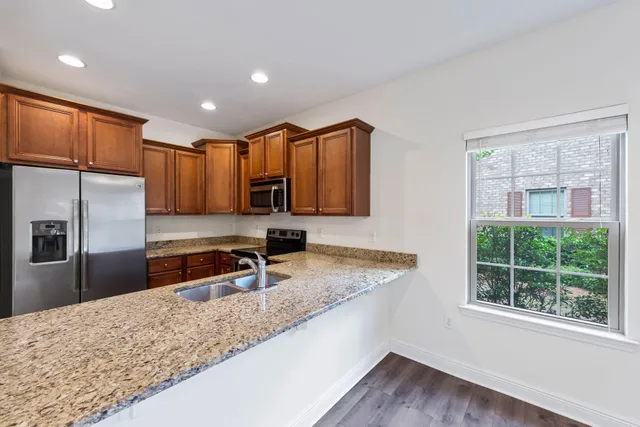 a kitchen with stainless steel appliances granite countertop a stove a refrigerator and a sink