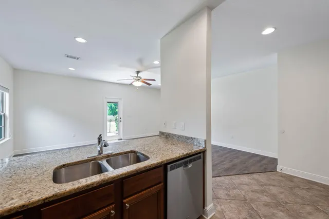 a view of a room with wooden floor and a ceiling fan