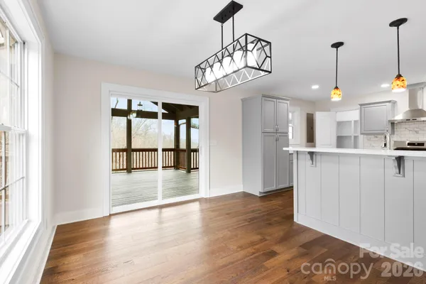 a view of a kitchen with wooden floor and a window