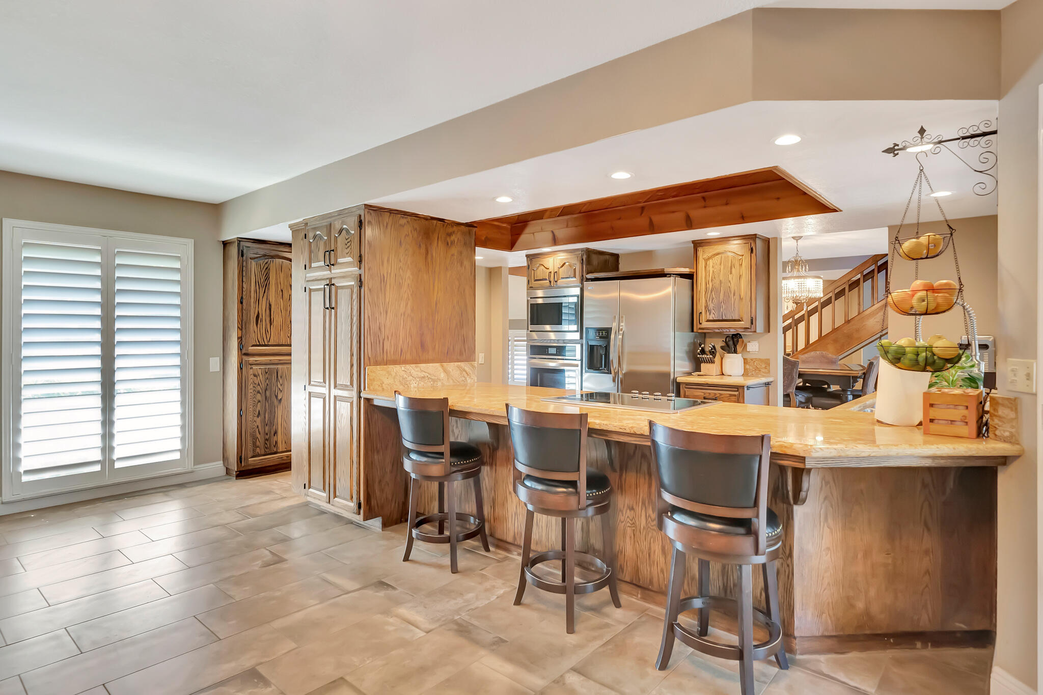 39844 Golfers Drive Palmdale, CA 93551 - Photo 21 of 87 a dining hall with stainless steel appliances kitchen island granite countertop a table and chairs in it
