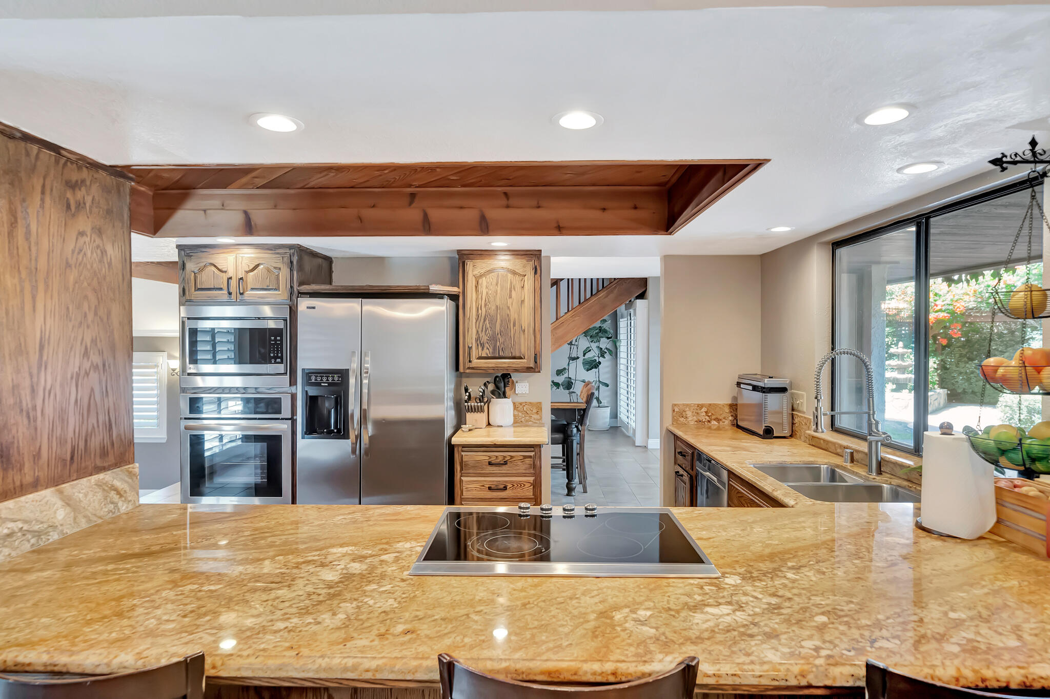 39844 Golfers Drive Palmdale, CA 93551 - Photo 23 of 87 a kitchen with stainless steel appliances kitchen island granite countertop a refrigerator and a stove top oven