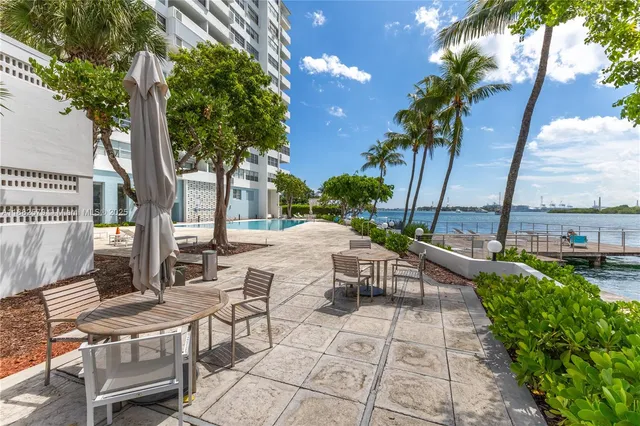 a view of a patio with table and chairs potted plants and palm tree