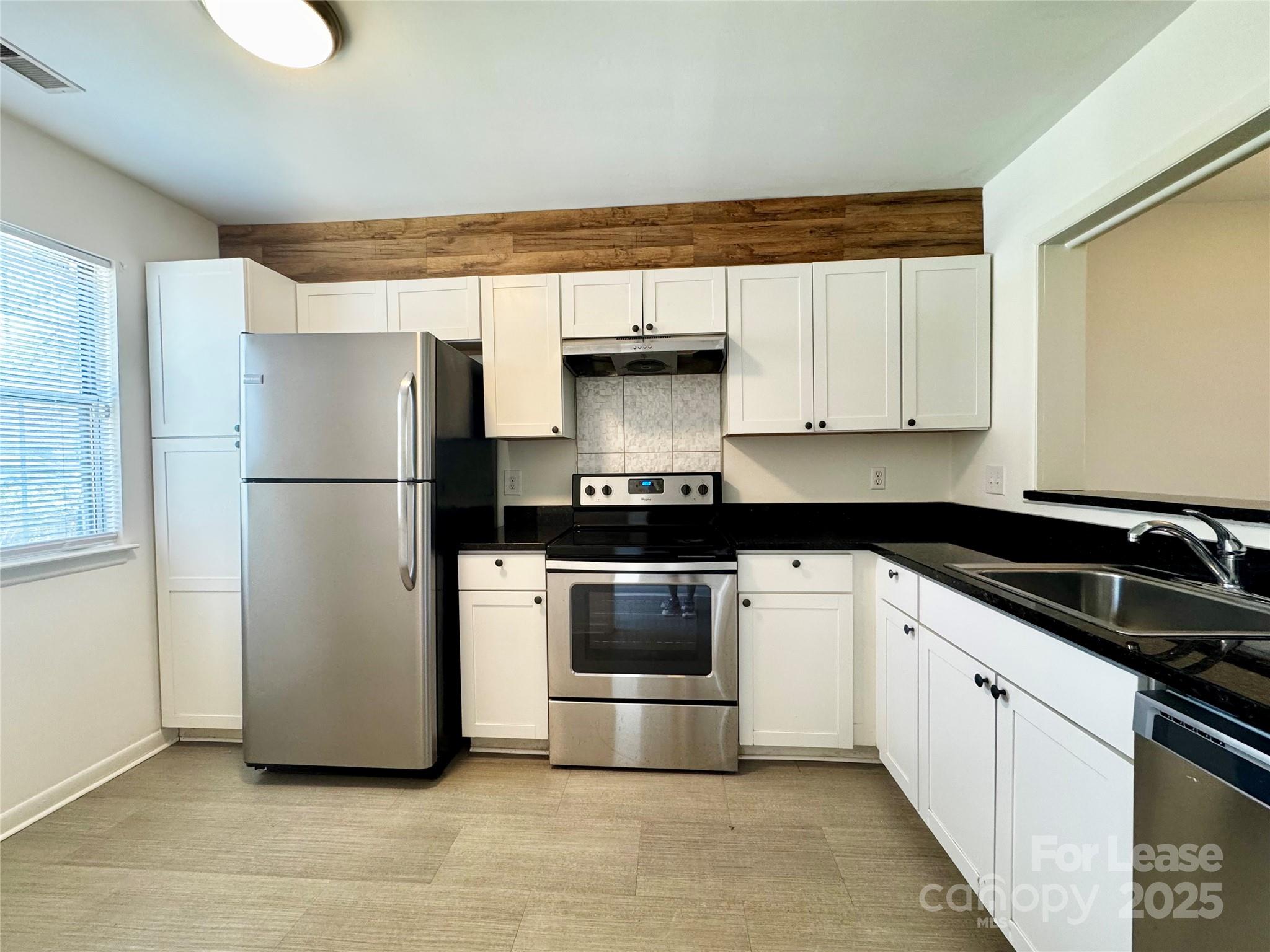 6102 Heath Ridge Court Charlotte, NC 28210 - Photo 1 of 23 a kitchen with a refrigerator and a stove top oven