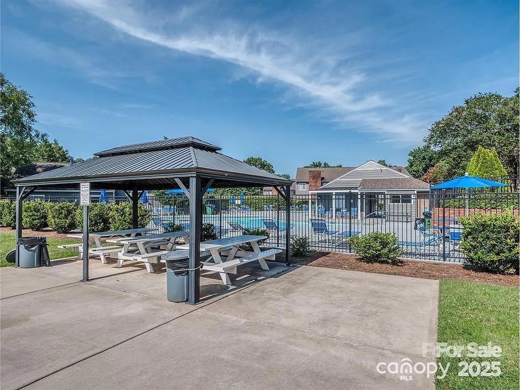 6102 Heath Ridge Court Charlotte, NC 28210 - Photo 22 of 23 a view of a patio with table and chairs under an umbrella
