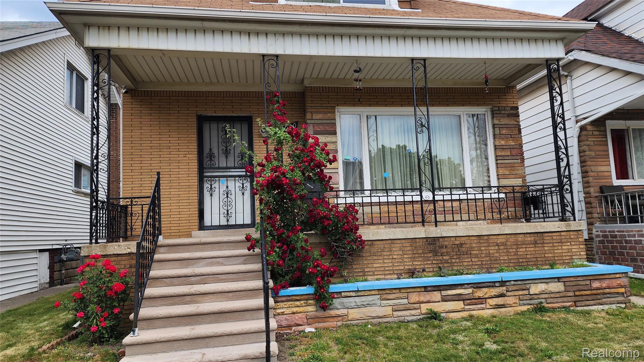 12020 Charest Street, Unit 2 Hamtramck, MI 48212 - Photo 1 of 21 Brick facade residence featuring a covered front porch with decorative iron railings