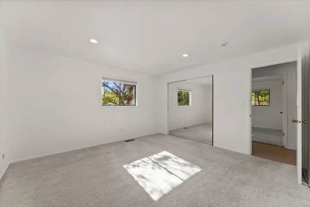 an empty room with windows and closet