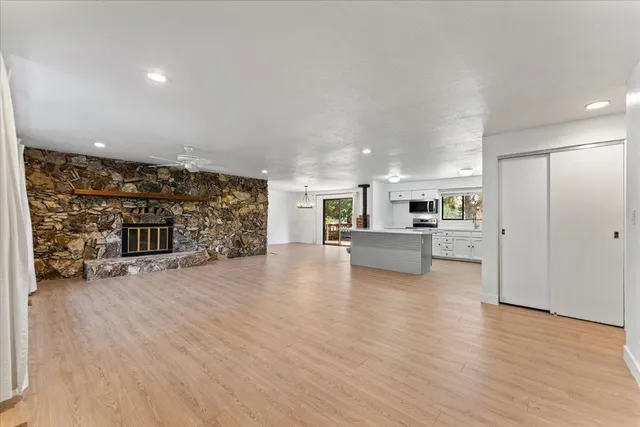 a view of a living room a kitchen with a sink and a refrigerator