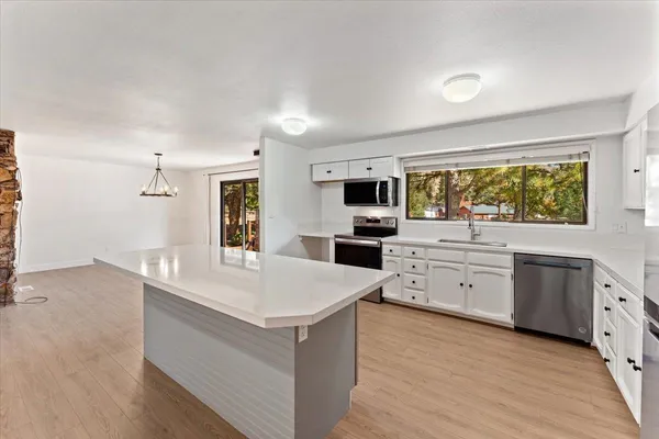 a kitchen with white cabinets and appliances