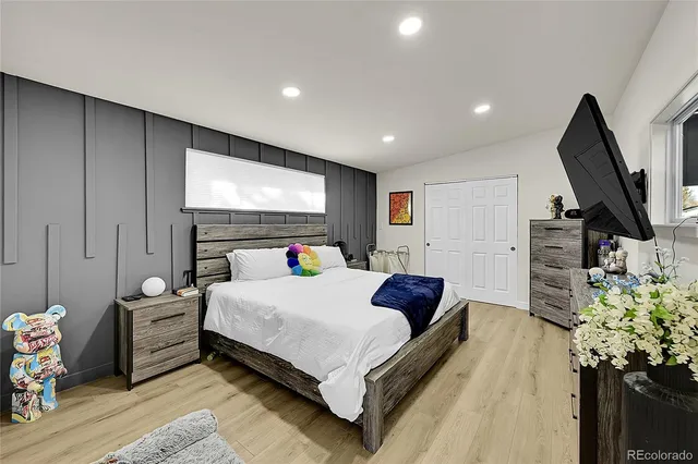 a spacious bedroom with a bed and a flat screen television
