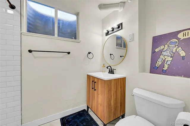 a bathroom with a toilet a sink and a mirror