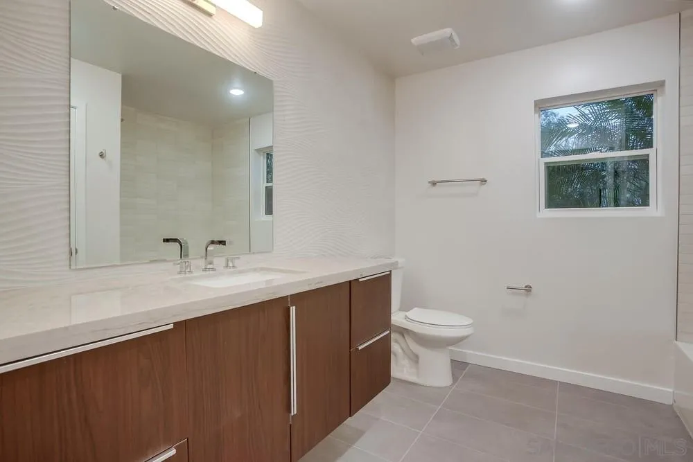 458 Avenida Adobe Escondido, CA 92029 - Photo 32 of 59 a bathroom with a toilet a sink a mirror and a window