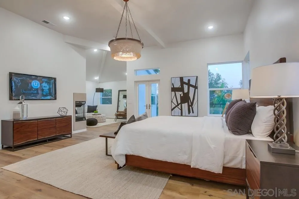458 Avenida Adobe Escondido, CA 92029 - Photo 7 of 59 a bedroom with a large bed and a chandelier
