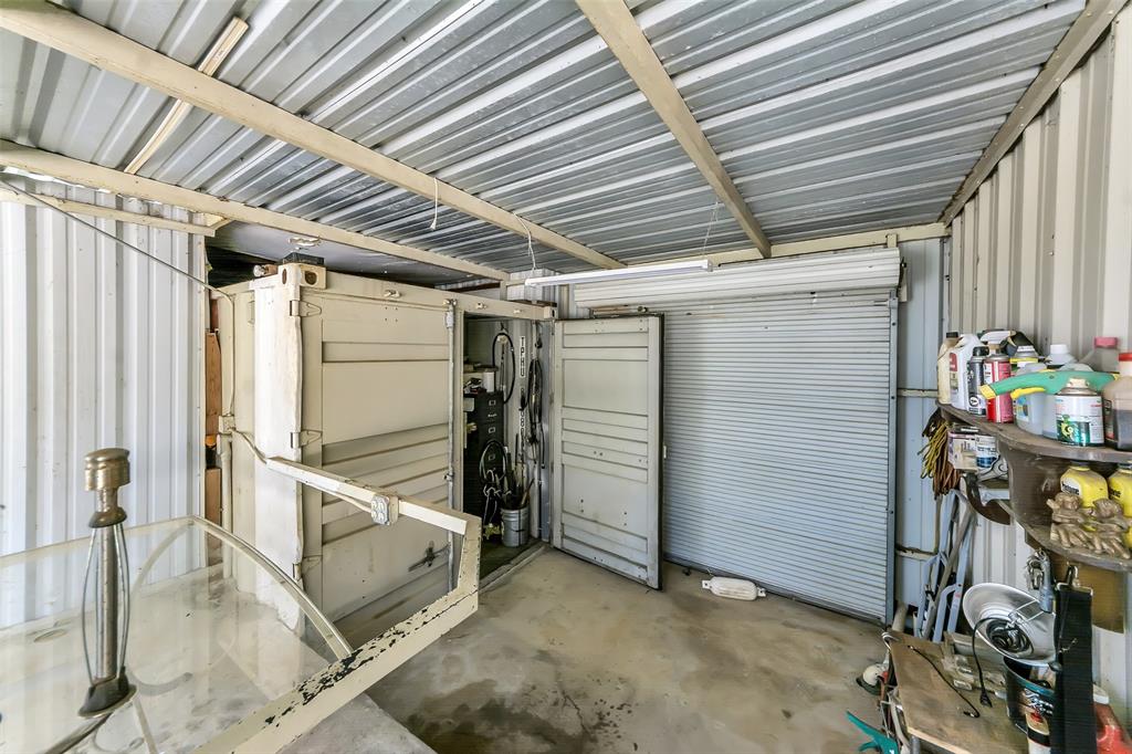 566 Selma Park Road Bowie, TX 76230 - Photo 31 of 40 Covered outdoor area featuring a corrugated metal roof, exposed wooden support beams, and concrete flooring