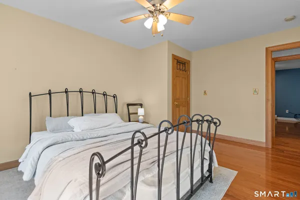 a bedroom with a bed and wooden floor