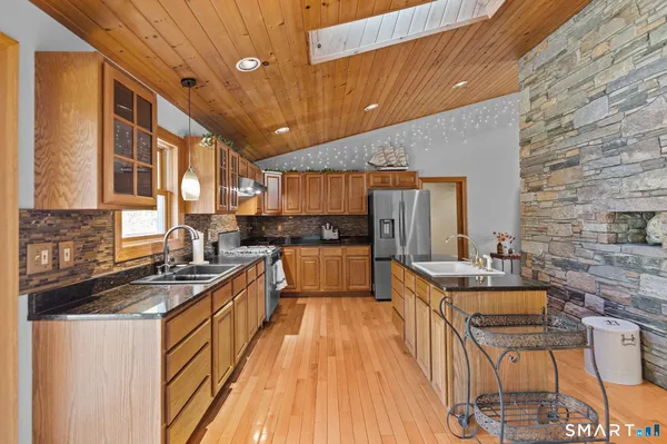 a kitchen with stainless steel appliances granite countertop a sink stove and cabinets