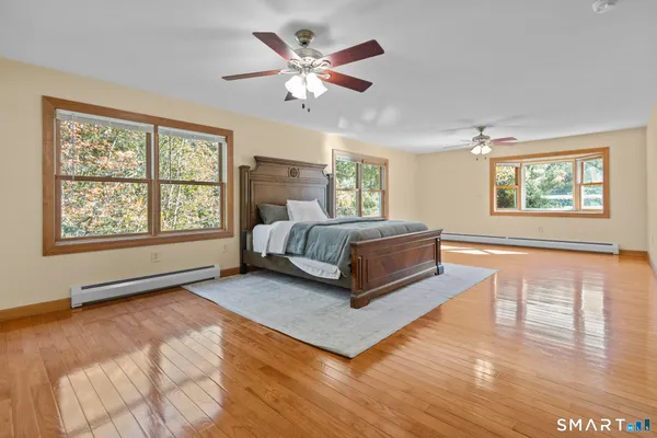 a spacious bedroom with a bed a window and a chandelier