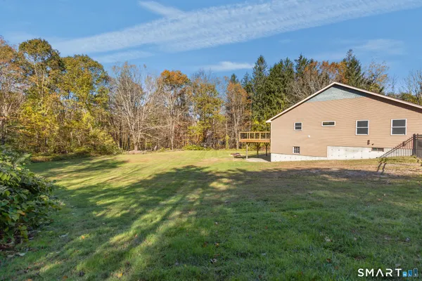 a view of a big house with a big yard and large trees