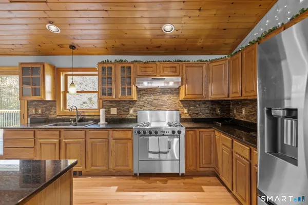 a kitchen with stainless steel appliances granite countertop a stove and a refrigerator