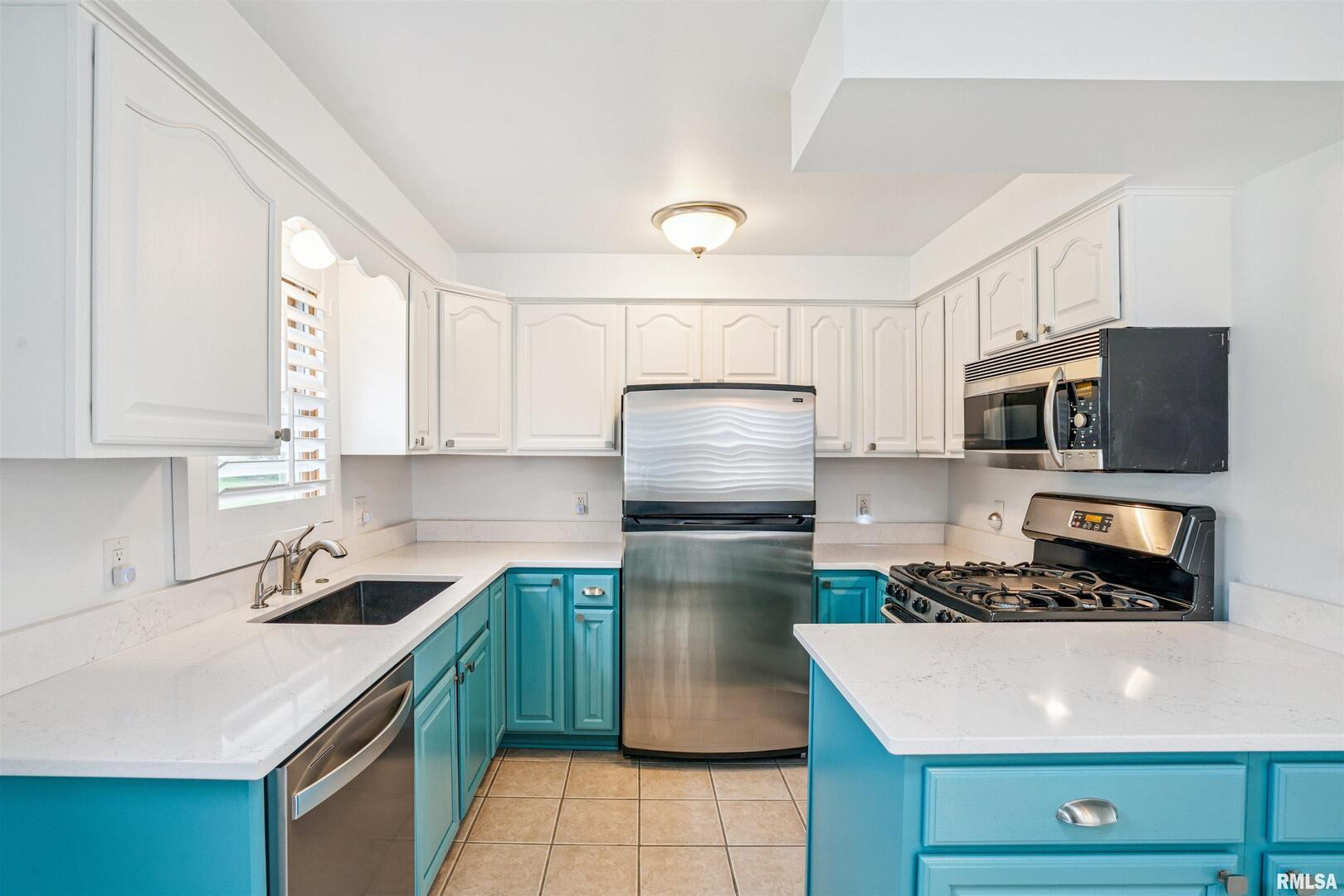 22799 Great River Road Le Claire, IA 52753 - Photo 11 of 48 a kitchen with a refrigerator a stove a microwave and cabinets