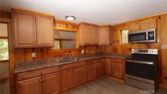 a kitchen with stainless steel appliances granite countertop a sink stove and microwave