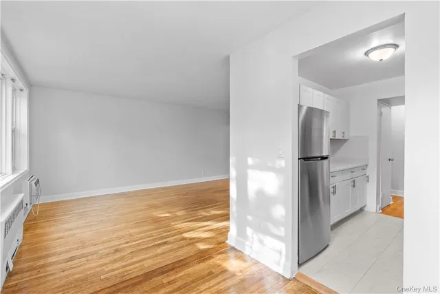 a view of a kitchen with refrigerator and wooden floor