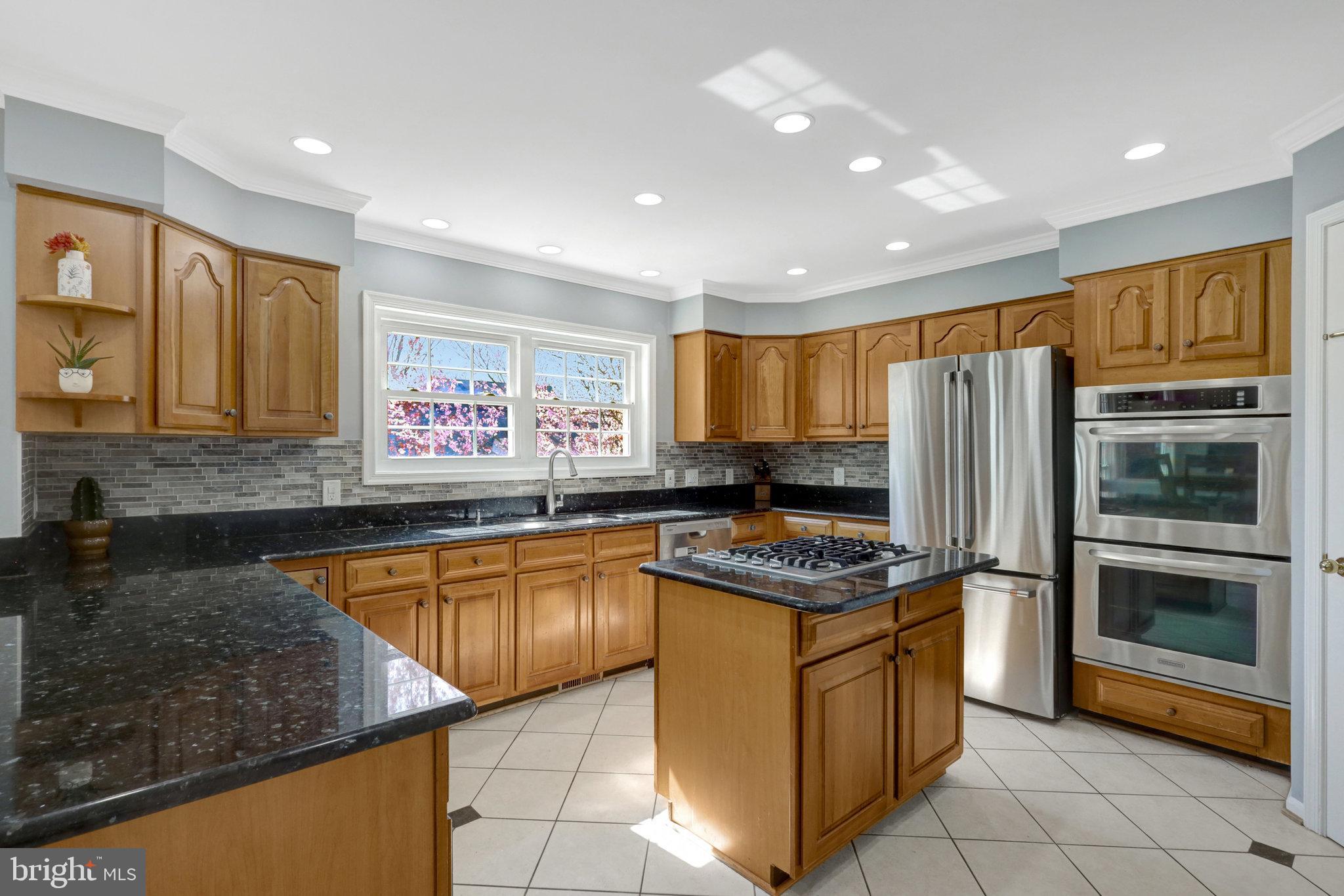 8497 Silverview Drive Lorton, VA 22079 - Photo 17 of 50 a kitchen with stainless steel appliances granite countertop a stove a sink and a refrigerator