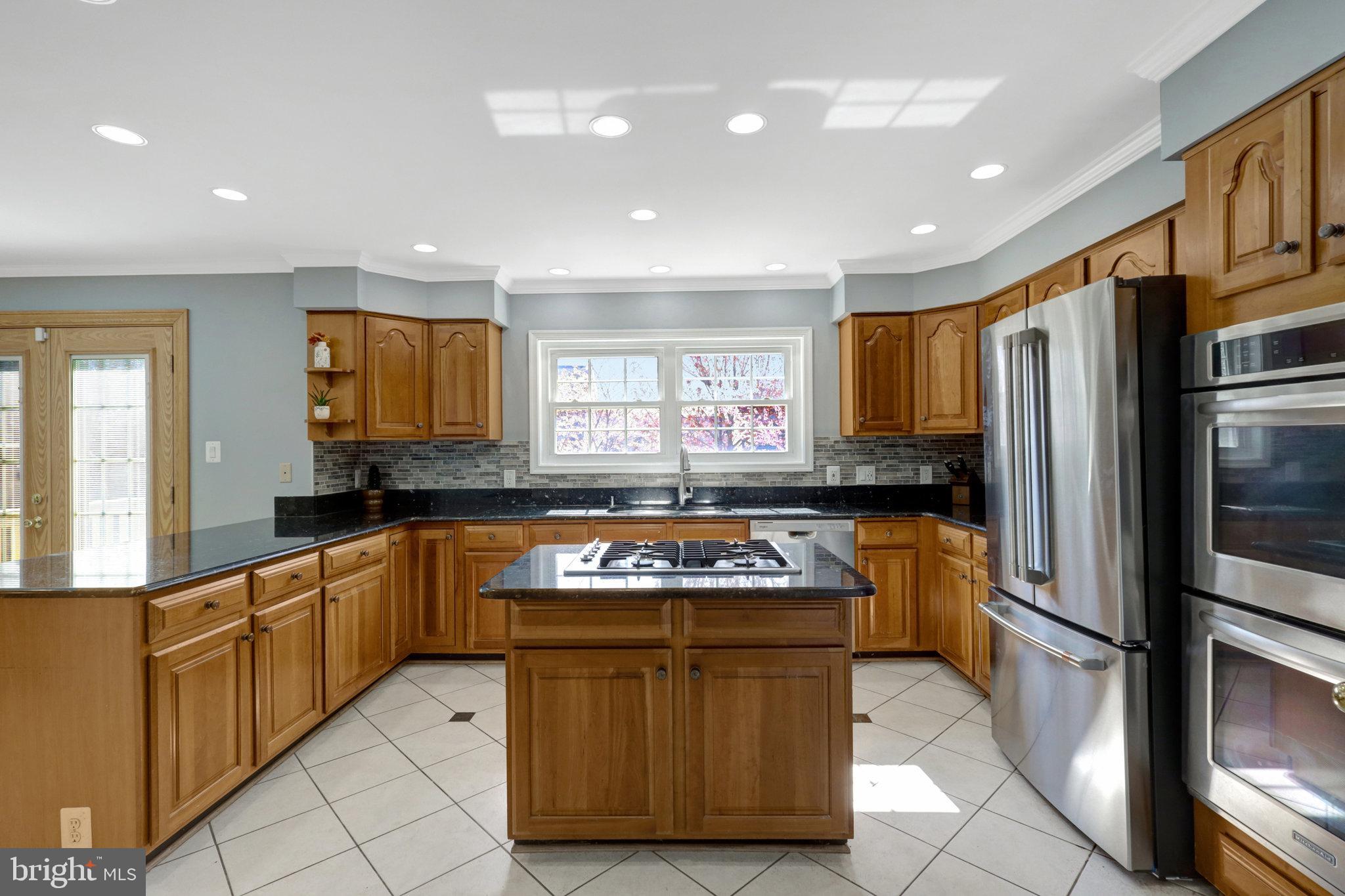 8497 Silverview Drive Lorton, VA 22079 - Photo 18 of 50 a kitchen with stainless steel appliances granite countertop a refrigerator and a stove top oven