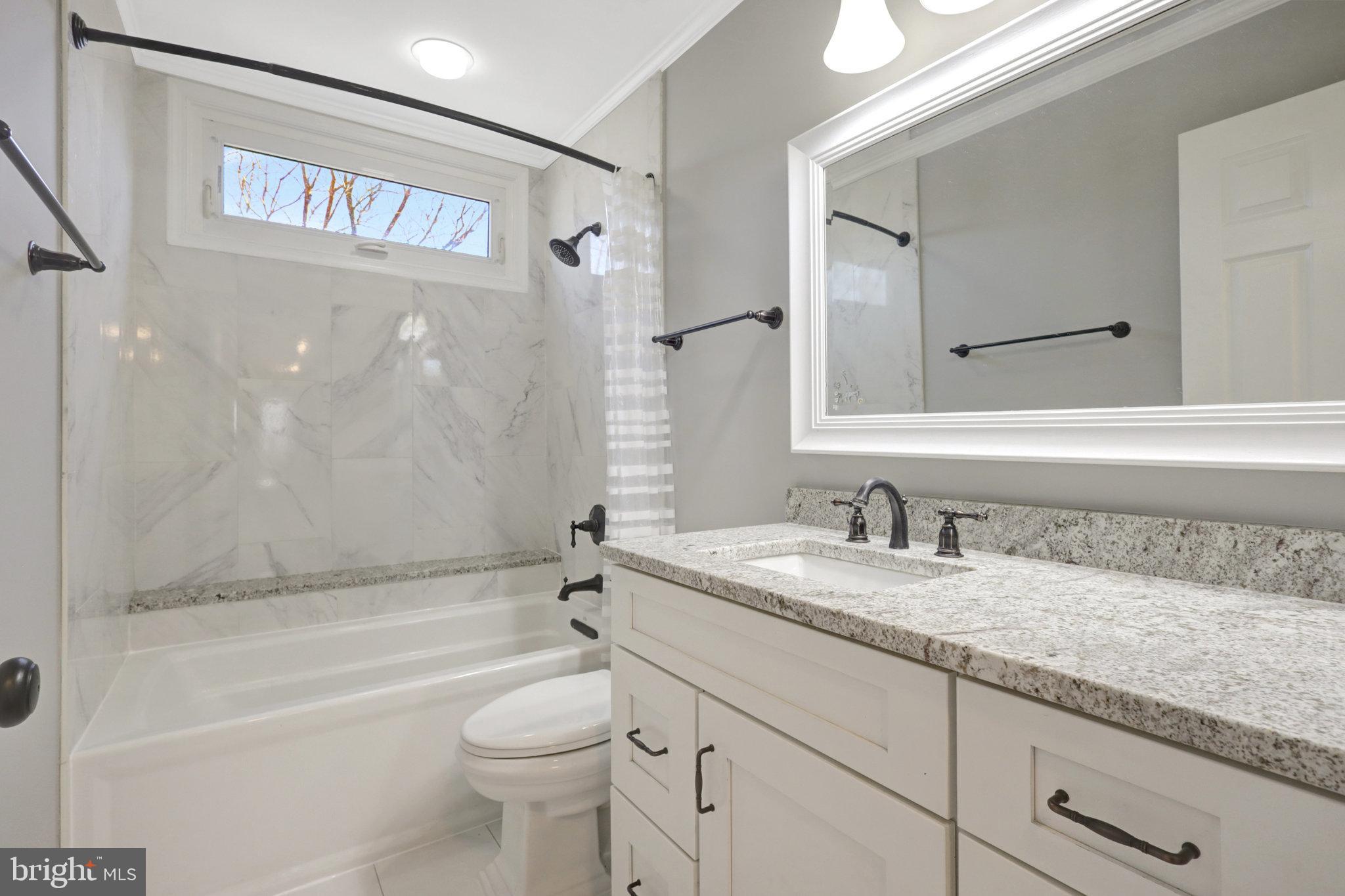 8497 Silverview Drive Lorton, VA 22079 - Photo 26 of 50 a bathroom with a granite countertop sink a toilet and a bathtub