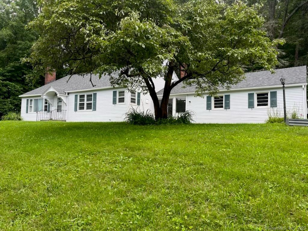 a front view of house with yard and green space