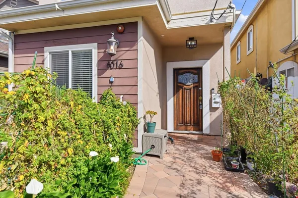 a view of yellow house with potted plants